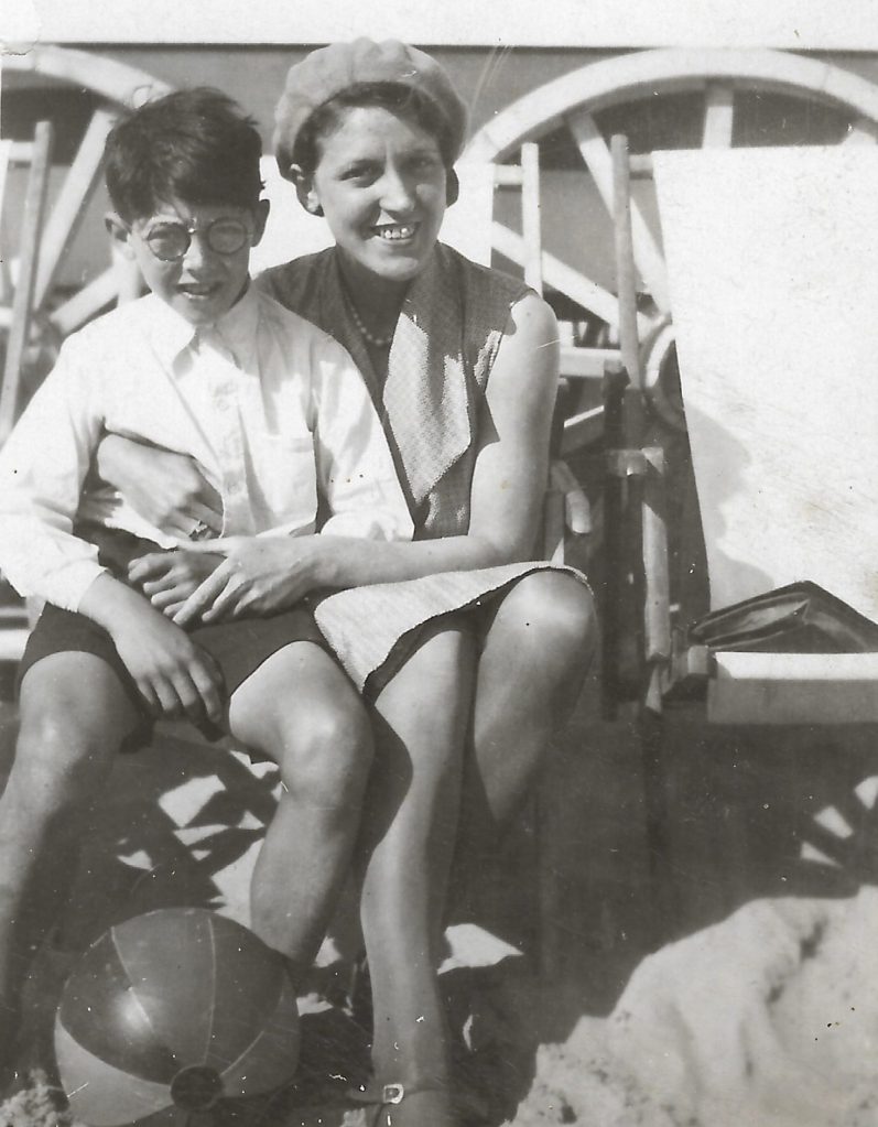 Summer holiday scene, smiling young woman, her arms round her 8 year old son.