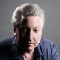 Face shot in colour, white man looking at the camera, serious expression